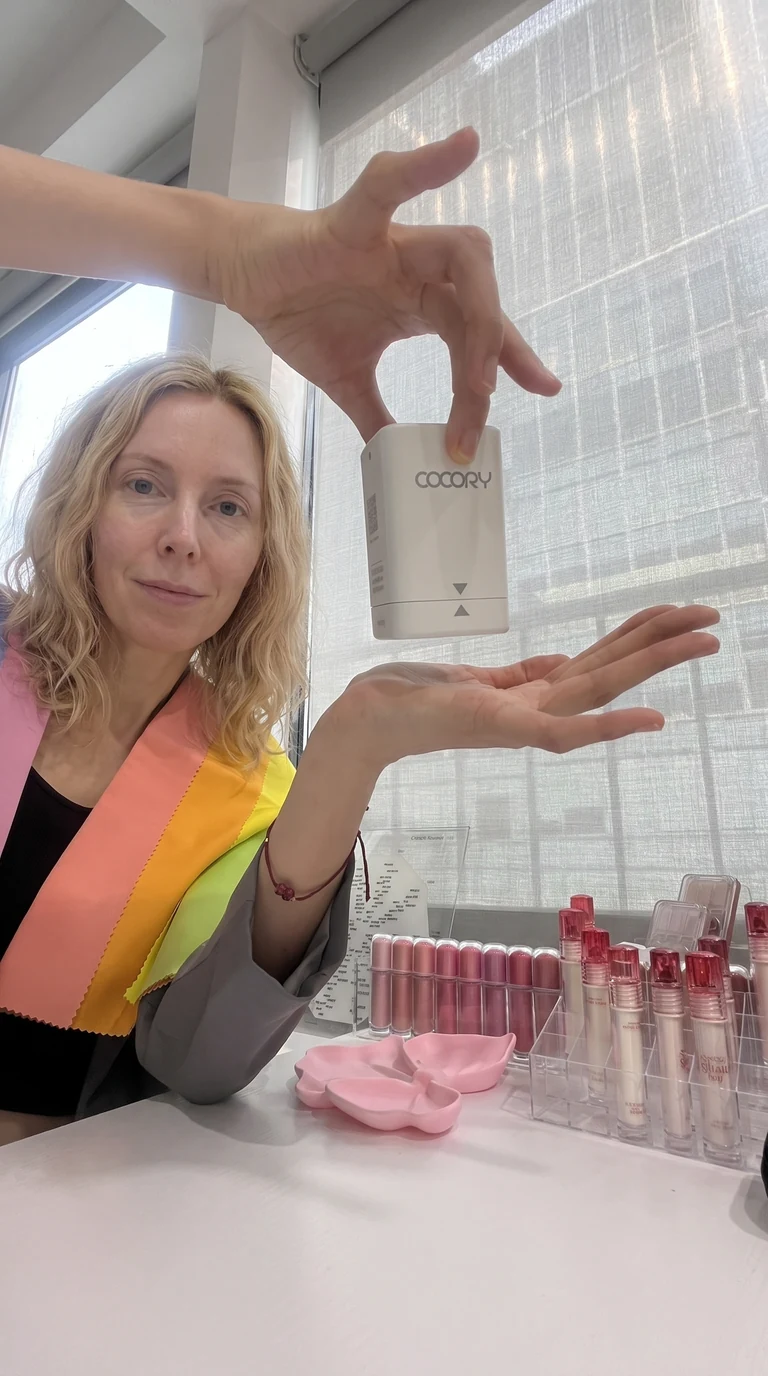 Client holding customized foundation sample after Cube spectrophotometer analysis at COCORY New York Midtown Manhattan studio
